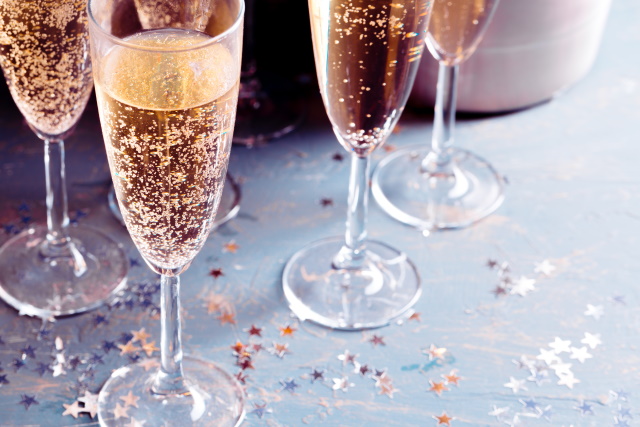 Flutes of Champagne on a table with festive decor.